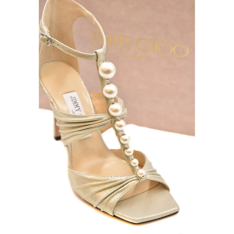 Jimmy Choo women leather sandal in beige with a gold metallic finish, stiletto heel, open toe, and white pearl embellishments