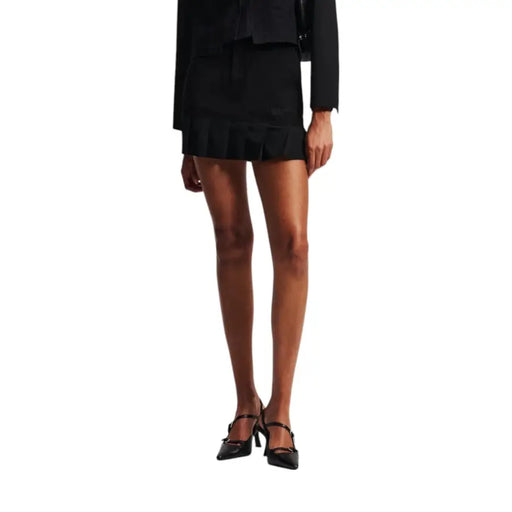 Black mini-skirt with ruffled hem, matching blazer, and pointed-toe double strap heels