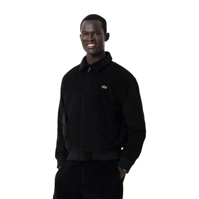 Schwarze Cord-Bomberjacke von Lacoste für Herren mit grünem Krokodil-Logo auf der linken Brust im klassischen Blazer-Stil.
