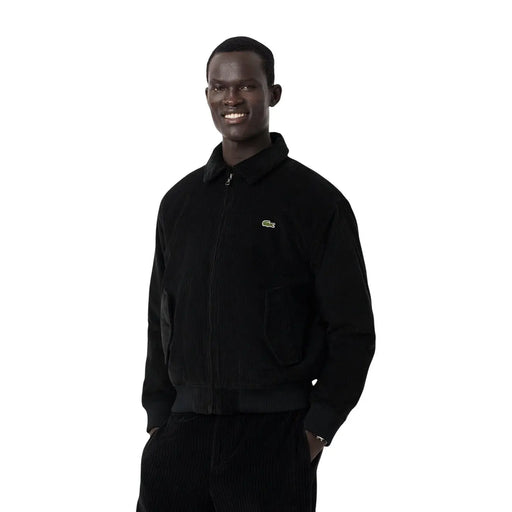 Schwarze Cord-Bomberjacke von Lacoste für Herren mit grünem Krokodil-Logo auf der linken Brust im klassischen Blazer-Stil.