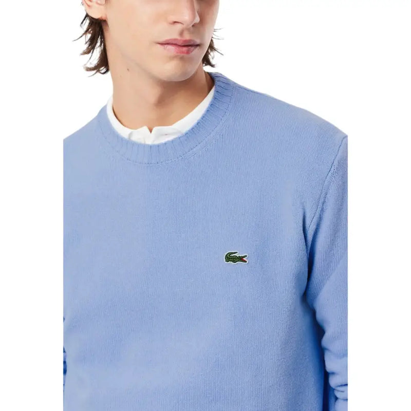 Hellblauer Lacoste Herren-Strickpullover aus Wolle mit Rundhalsausschnitt und kleinem grünen Krokodil-Logo auf der linken Brust.