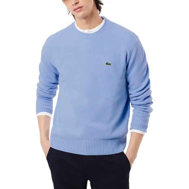 Hellblauer Lacoste Herren-Strickpullover aus Wolle mit Rundhalsausschnitt, gerippten Bündchen und grünem Krokodil-Logo auf der linken Brust.