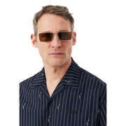 Ein Herrenhemd von Lacoste, kombiniert mit einer rechteckigen, braun getönten Sonnenbrille mit Metallrahmen.