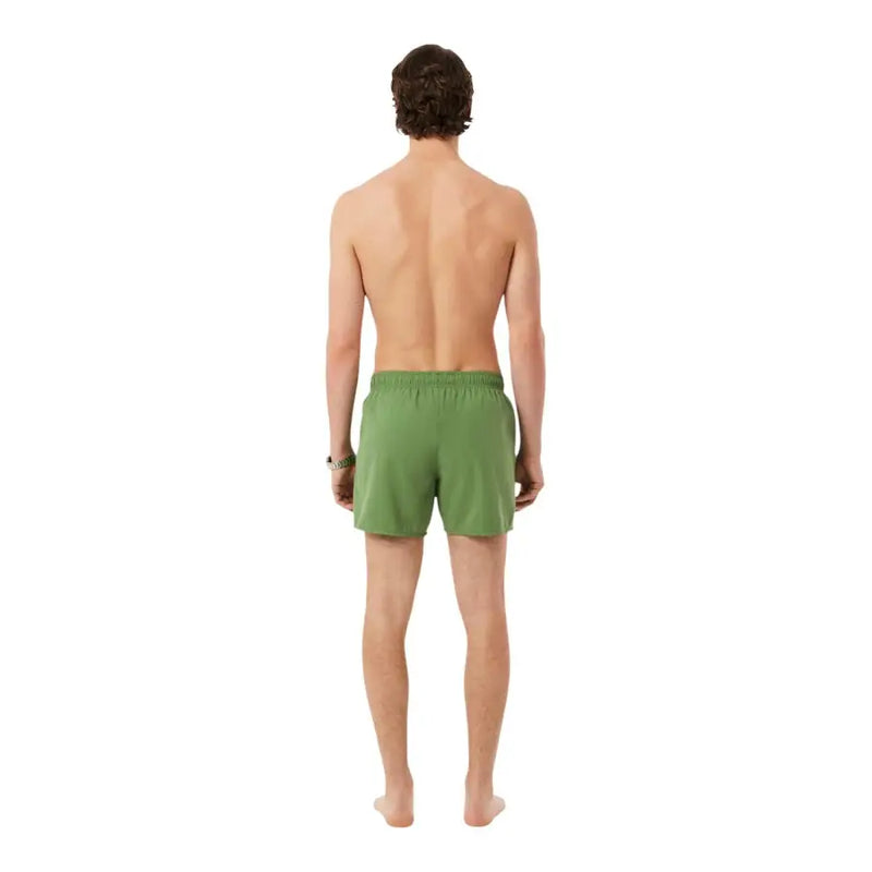 Eine grüne Lacoste Herren-Badehose aus Polyester mit elastischem Bund und Taschen