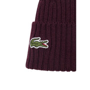 Lacoste Wollmütze für Herren in bordeauxrotem Rippstrick mit grünem Krokodillogo und weiß-roten Akzenten, Vorderansicht