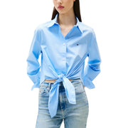Light blue organic cotton long-sleeve button-up shirt tied at waist with light wash jeans