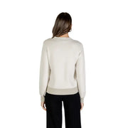 Women’s light neutral crewneck sweatshirt with ribbed hem and cuffs, paired with black wide-leg pants