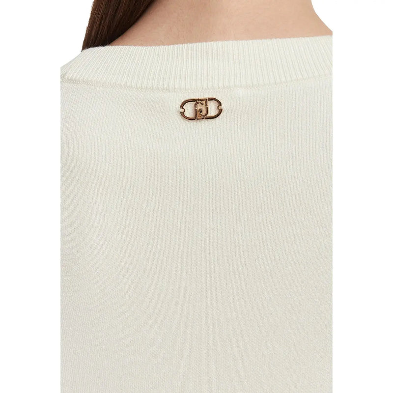 Ein goldfarbener Logo-Pin aus Metall auf der Rückseite eines weißen, gerippten Damenpullovers von Liu Jo aus Wollmischung mit Blumenmuster.