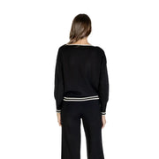 Woman wearing Liu Jo black long round neck knit sweater and pants with white stripe details