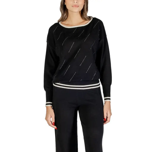 Black long-sleeved knit sweater with white striped trim and diagonal accents for women