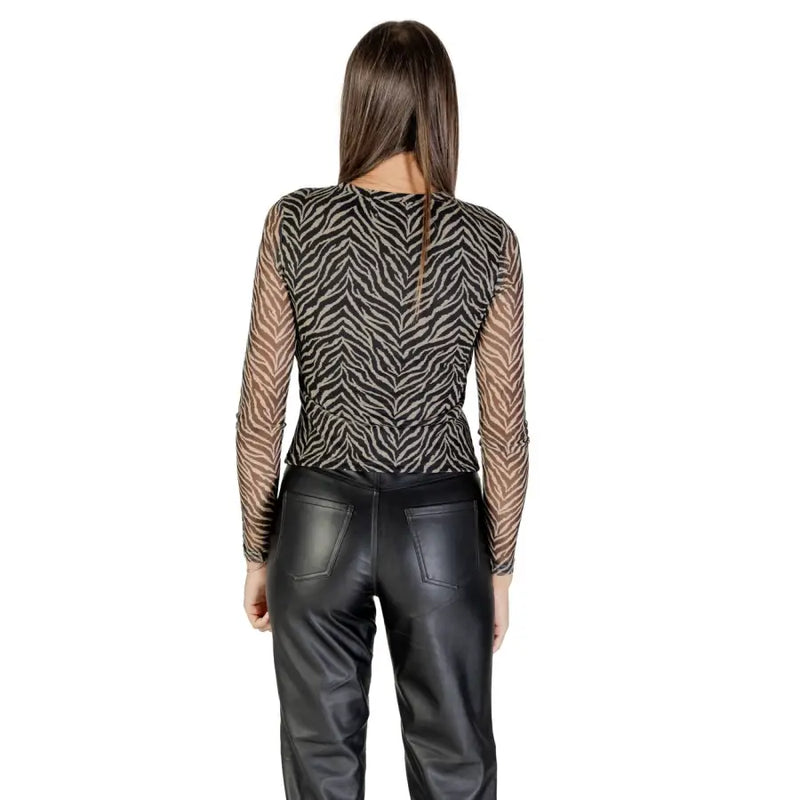 Woman wearing a black and beige zebra print long-sleeve top and black leather pants