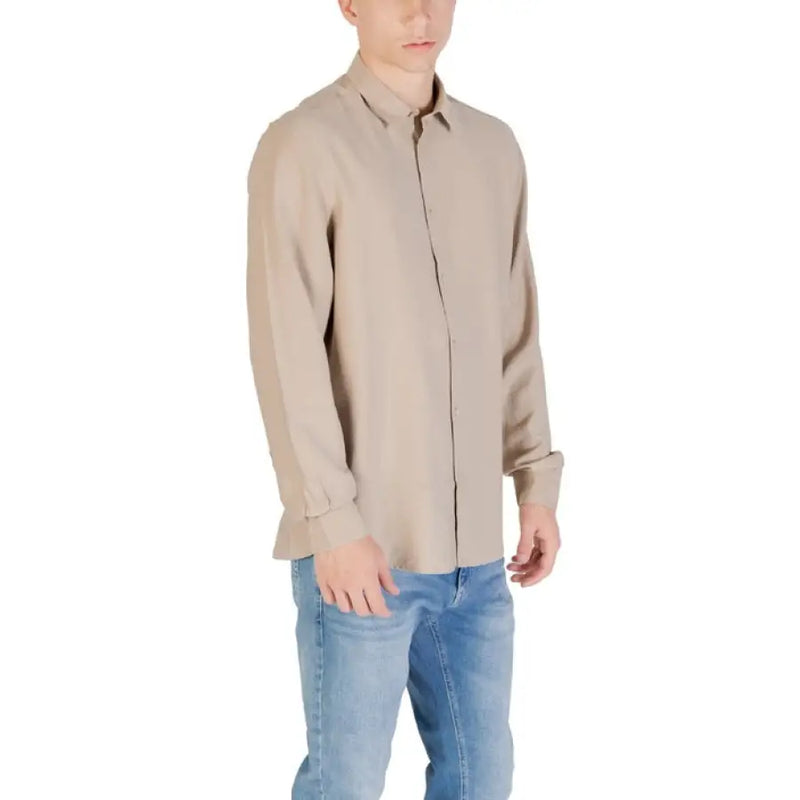 Man wearing beige long sleeve shirt and blue jeans in Beige and Tan Long Sleeve Shirts with Blue Jeans product image