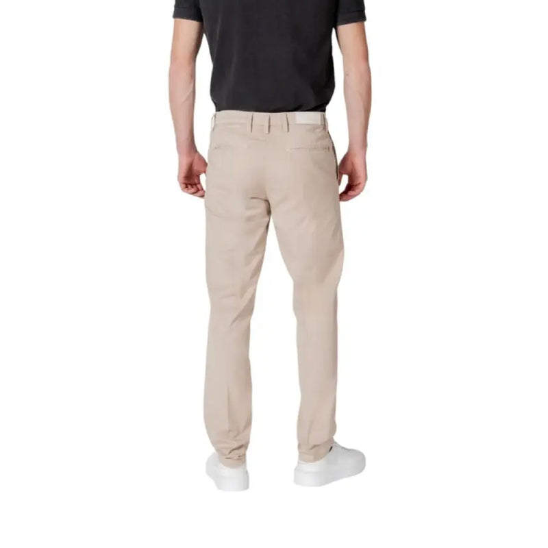 Man showcasing Replay Men Beige Trousers featuring zip and button closure