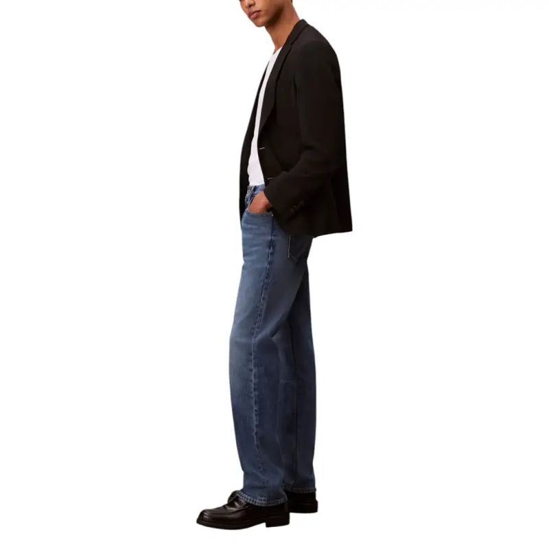 Man in a black blazer and blue jeans modeling the product named Man in Black Blazer and Blue Jeans