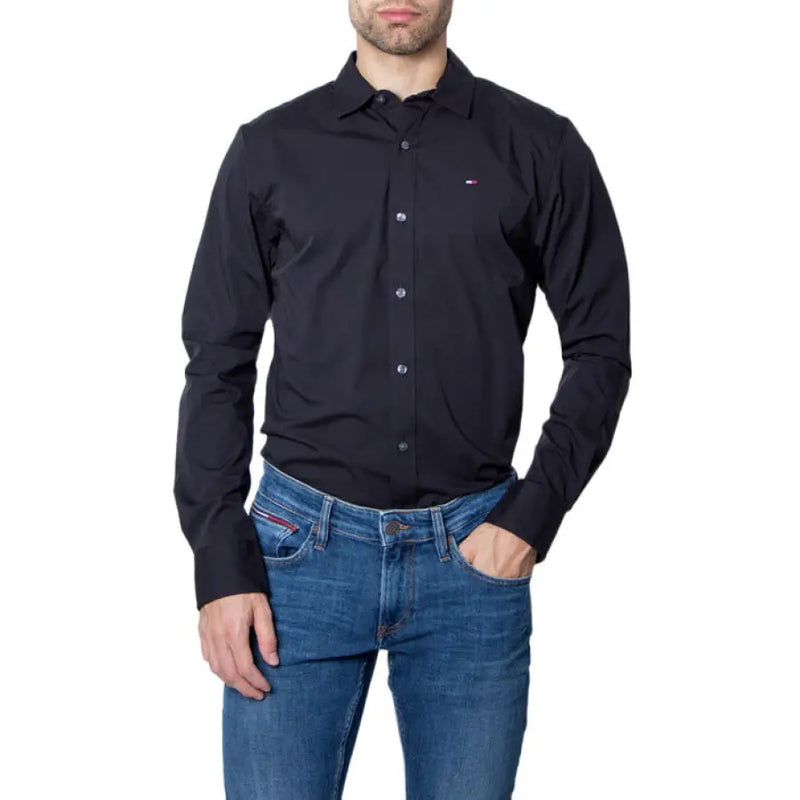 Man in a black button-down shirt and blue jeans modeling the product