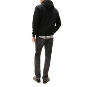 Man wearing a black hooded sweatshirt and jeans, showcasing casual men’s fashion