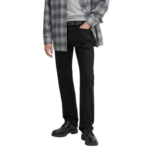 Man wearing black jeans and dress shoes showcasing Mens Black Straight Leg Trousers