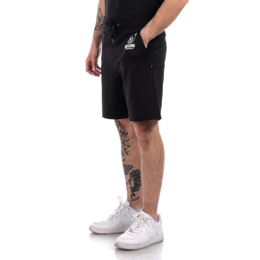 
                      
                        Man in Moschino Underwear shorts showcasing urban style clothing in a city setting
                      
                    