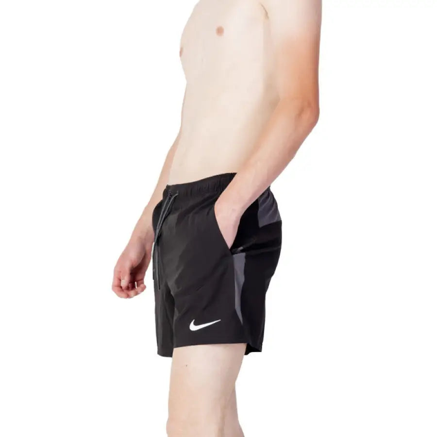 
                      
                        Nike Swim men’s swimwear for spring summer - man in black shorts and white shirt
                      
                    