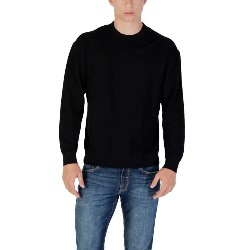Man wearing a black sweater and blue jeans showcasing the Taupe Patterned Crewneck Sweater