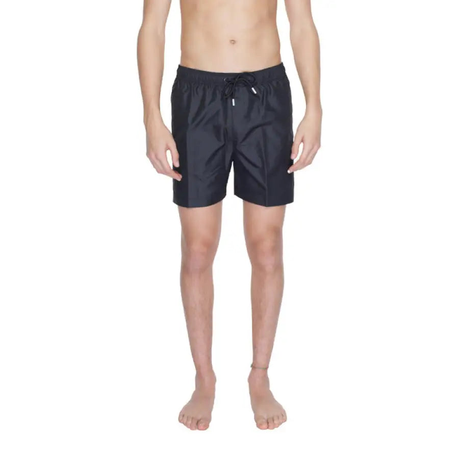 
                      
                        Calvin Klein swimwear model in black swimsuit and shorts
                      
                    