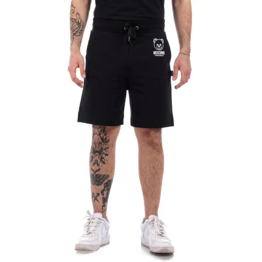 Man in Moschino Underwear shorts showcasing urban style clothing in city setting
