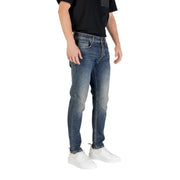 Man wearing blue jeans and white sneakers showcasing stylish men’s casual wear