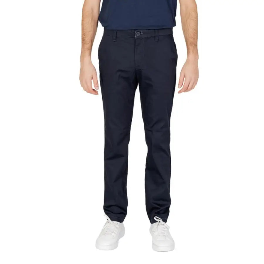 Man modeling Armani Exchange men trousers in blue polo and black pants