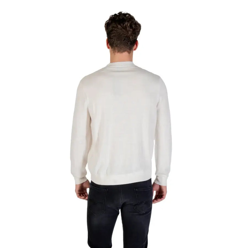 Man wearing a cream-colored sweater and dark jeans showcasing the White Long Sleeved Crewneck Sweatshirt