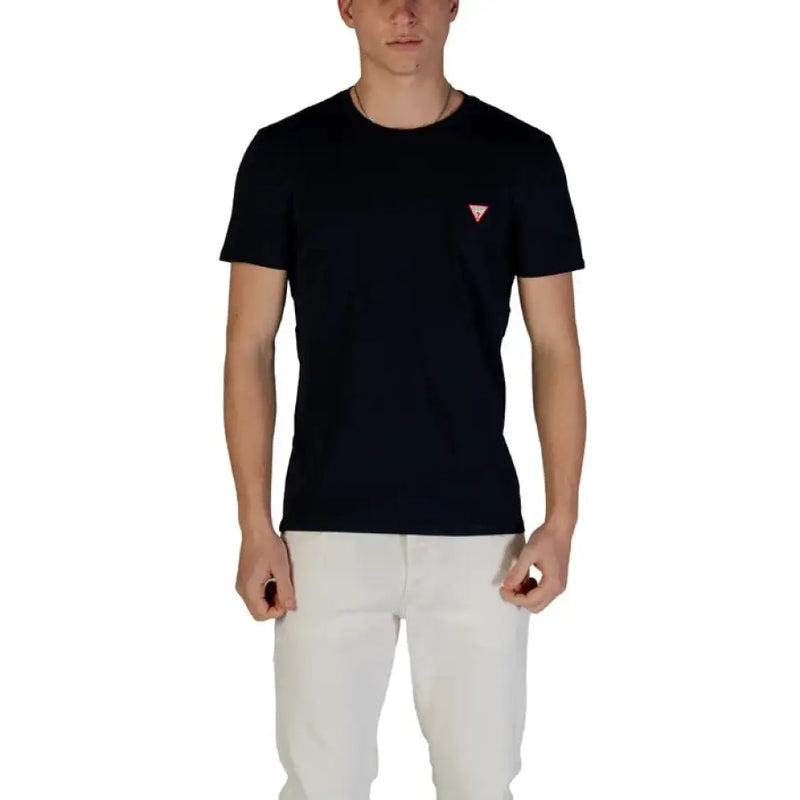 Man wearing a dark blue T-shirt and white pants showcasing Guess Men’s White Round Neck T-Shirt