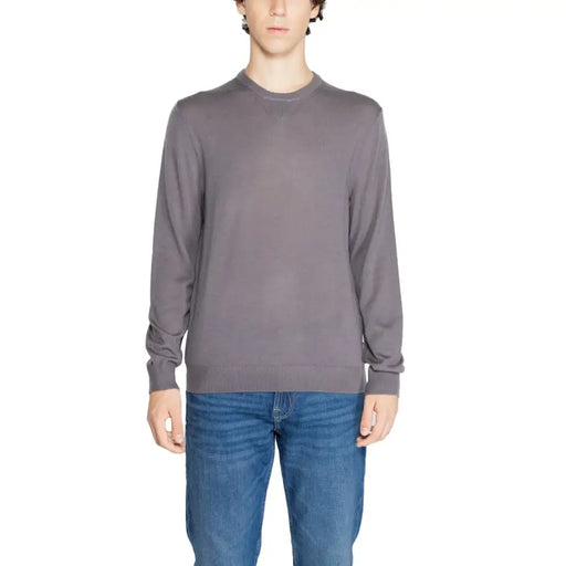 Mann trägt Armani Exchange blauer Herrenpullover aus Wollmischung und blaue Jeans