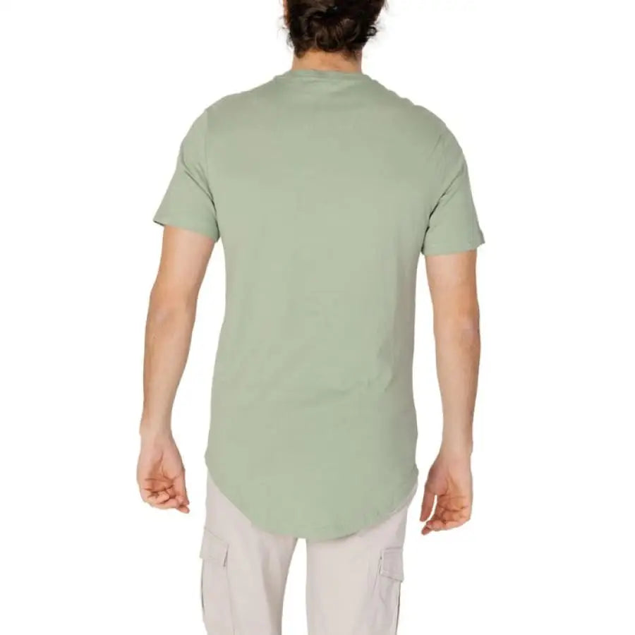Only & Sons men t-shirt model in green shirt and white pants apparel accessories