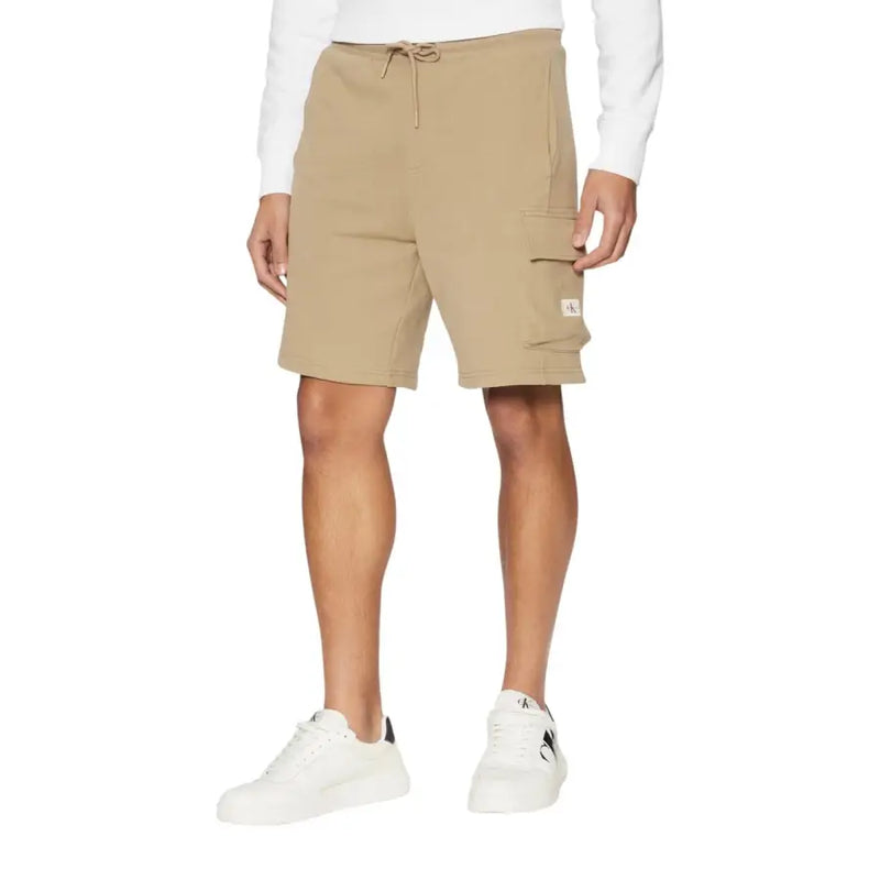 Man wearing khaki cargo shorts and black tank top for men’s casual wear