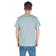 Man wearing a light blue Calvin Klein T shirt and jeans, showcasing casual style