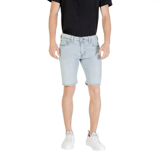 Man wearing light blue denim shorts showcasing casual summer fashion