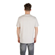 Man wearing a light-colored T shirt with black logo and gray jeans displayed in product listing