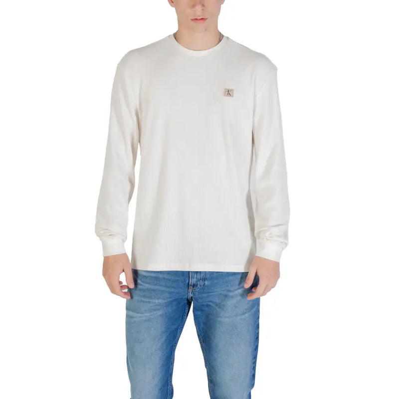 Man wearing an off-white long-sleeved shirt and blue jeans for the product Man in Long Sleeve Shirt and Blue Jeans