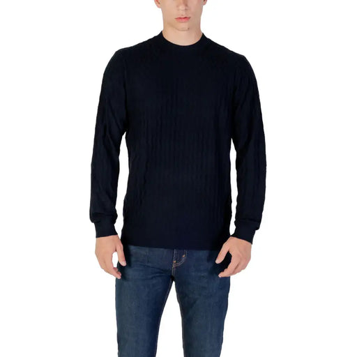 Man wearing navy textured long sleeve sweater and jeans showcasing stylish casual wear