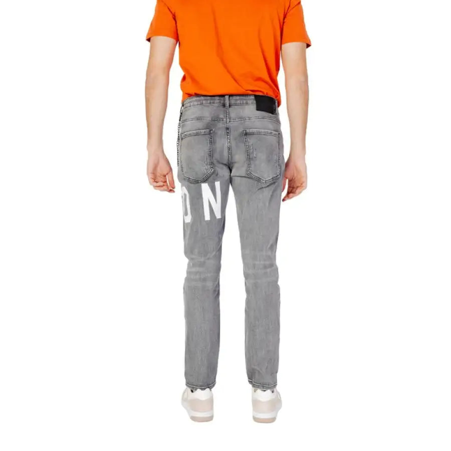 
                      
                        Man in orange shirt and Icon Men Jeans showcasing urban city fashion
                      
                    