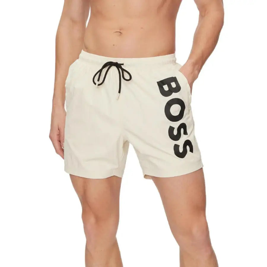 Man modeling Boss Men Swimwear with Boss logo on white shorts