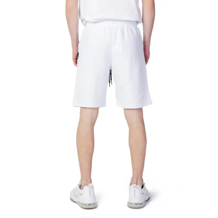 Man wearing Icon urban style clothing, white shorts and t-shirt in city