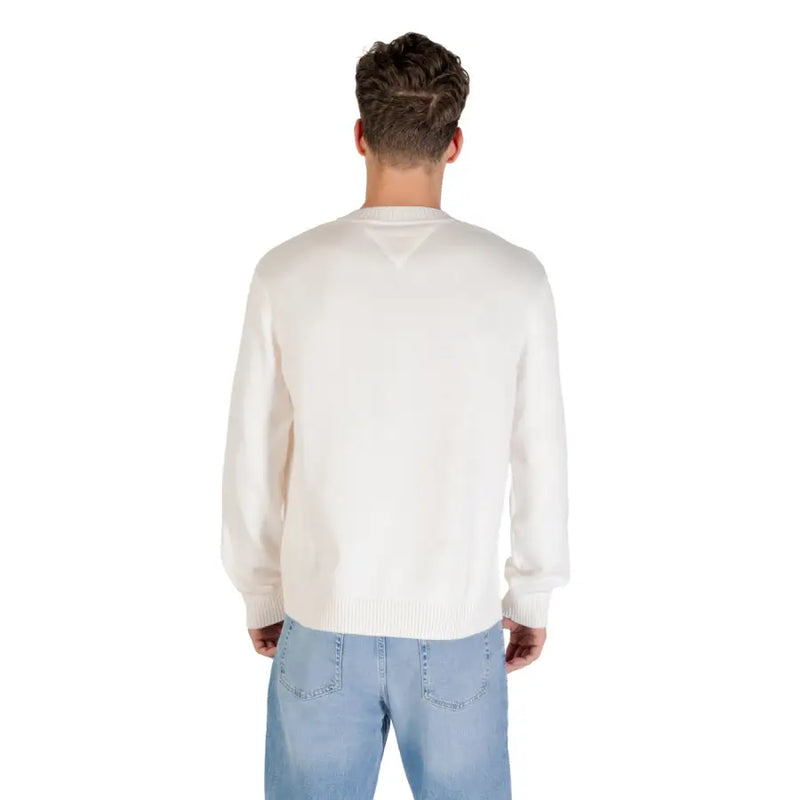 Man wearing a white sweater with red logo and blue jeans for the White Sweater With Red Logo product