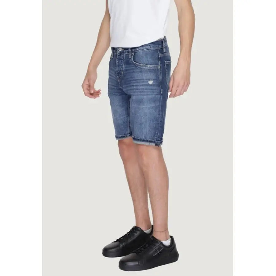 
                      
                        Antony Morato men shorts in urban style, man in white t-shirt and blue denim
                      
                    