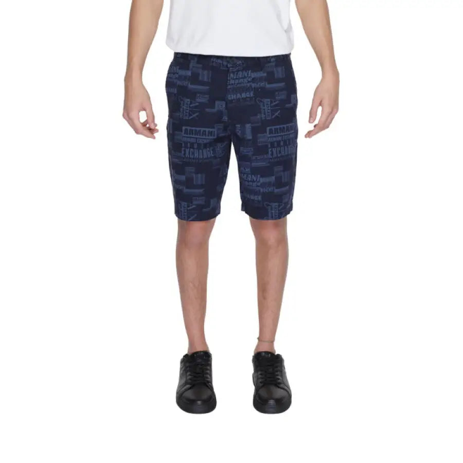 Man modeling Armani Exchange blue shorts and white shirt for urban city fashion