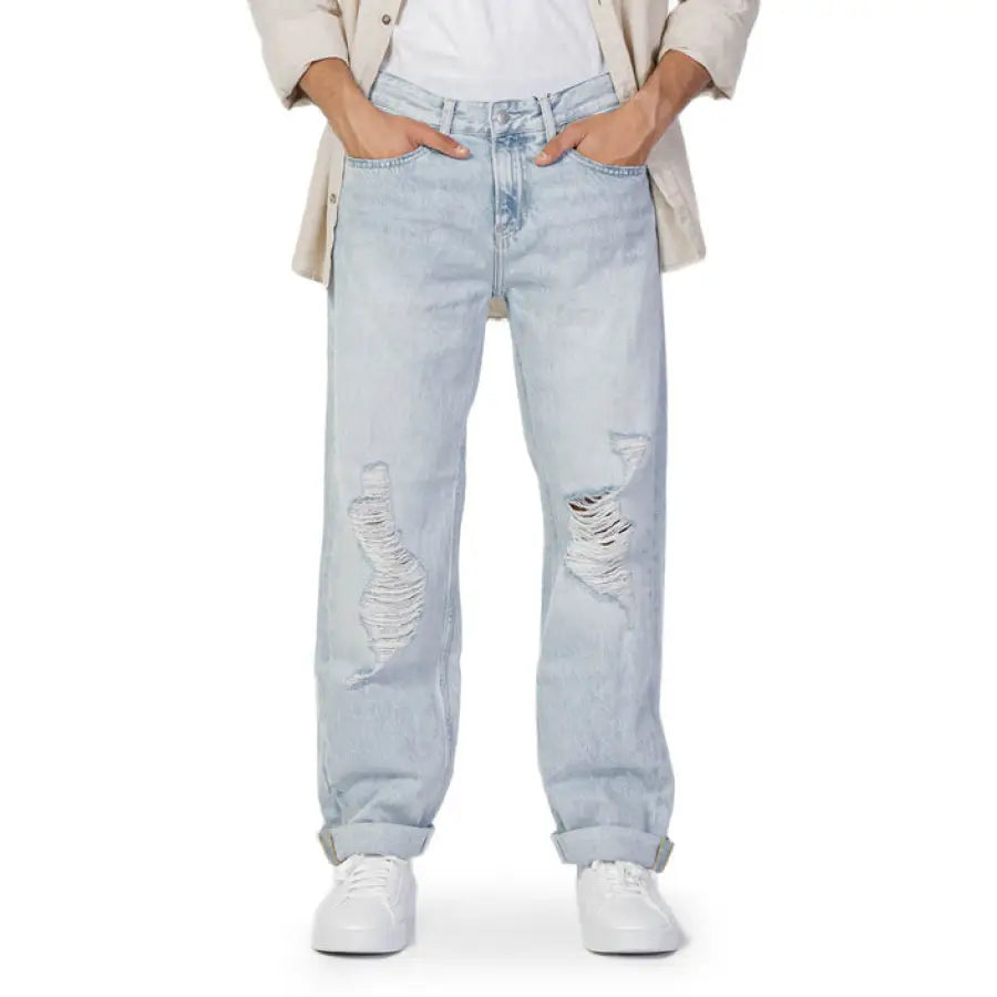 Man wearing Calvin Klein Jeans in white t-shirt showcases Calvin Klein style