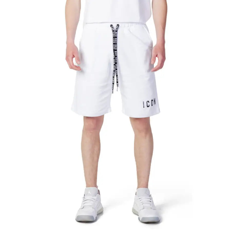 Man in Icon urban style clothing, showcasing white T-shirt and Icon Men Shorts in city