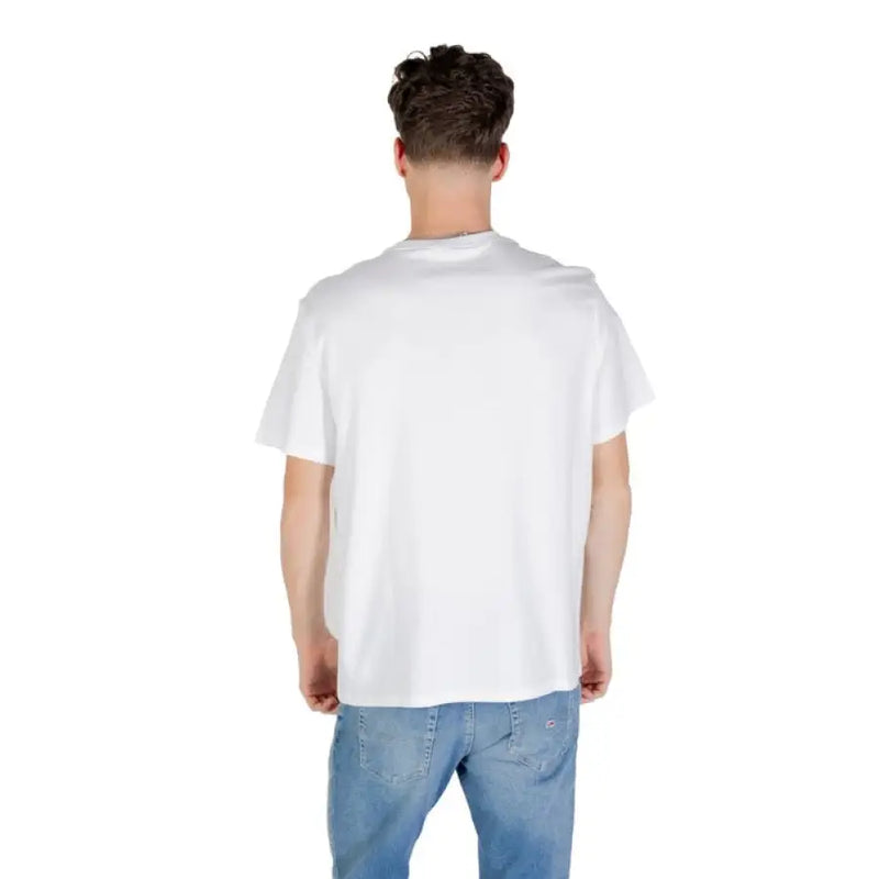 Man wearing a white crewneck T shirt and blue jeans posing confidently