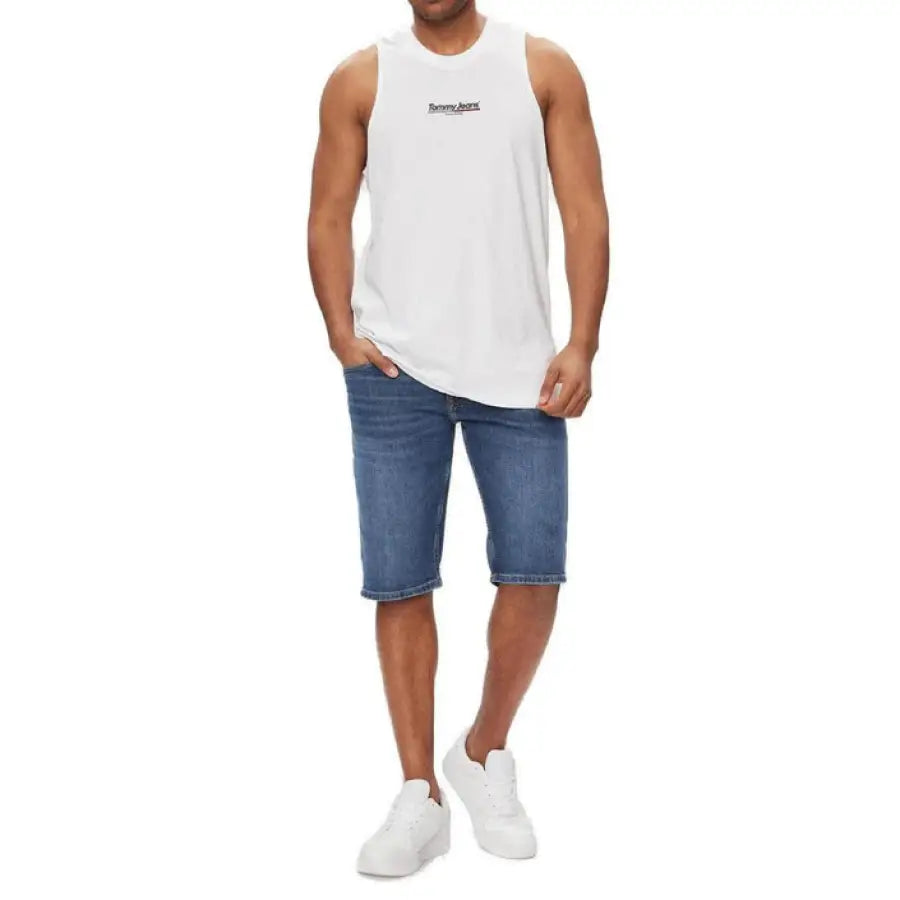 
                      
                        Man in Tommy Hilfiger jeans and white tank top showcasing style
                      
                    