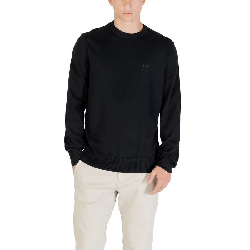 Man wearing a black long-sleeved shirt and light-colored pants showcasing casual style