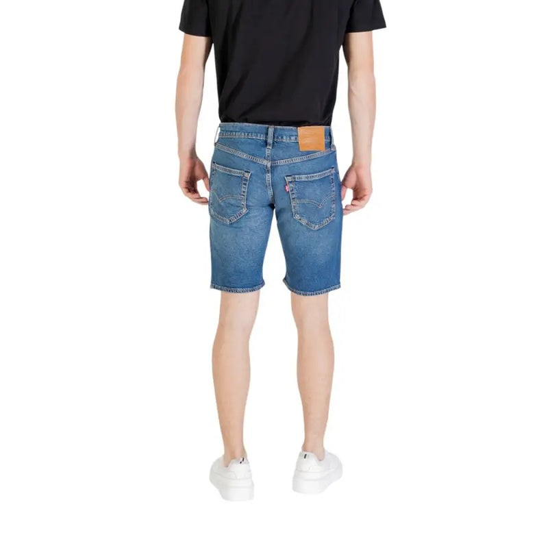 Die Rückseite der blauen Herren-Jeansshorts zeigt das klassische Fünf-Taschen-Design und den hellbraunen Leder-Markenaufnäher am Bund.